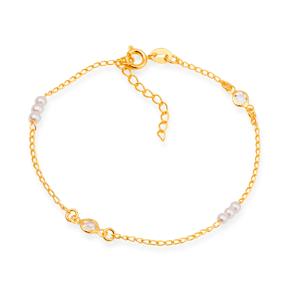 Pulseira dourada com pérolas e pontos de luz, sobre fundo claro